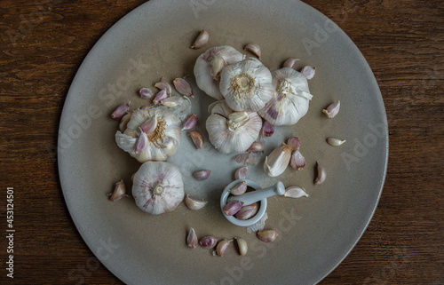 Garlic bulbs and Garlic cloves in Ceramic plate on Wooden rustic table. Copy space Concept of healthy food. Top view, Selective focus.