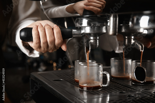 Barista making espresso using professional coffee machine  closeup