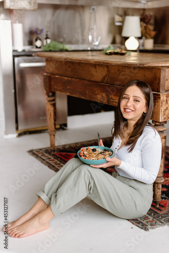 Smiling young woman holding granola bowl photo