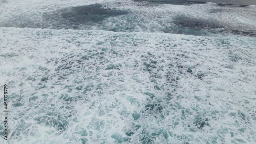 Aerial flight over ocean waves crashing and ocean wash
