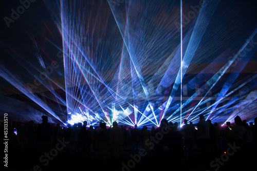 blue laser lights and people silhouettes at concert photo