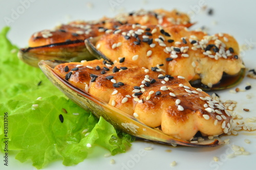 Baked Mussels under Cream Cheese with Caviar on white plate