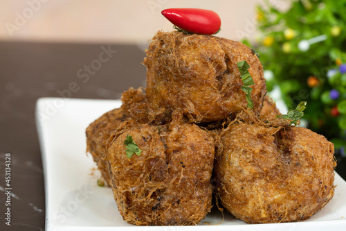 A serving of tauhu bergedil, a famous Malaysian dish with spicy soy sauce as dips. Blurred background