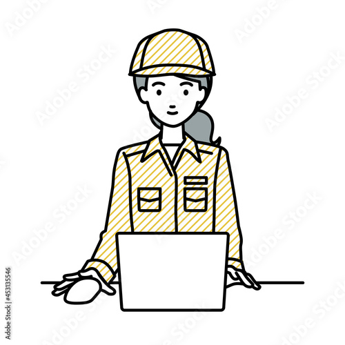 デスクで座ってPCを使っている作業員の女性