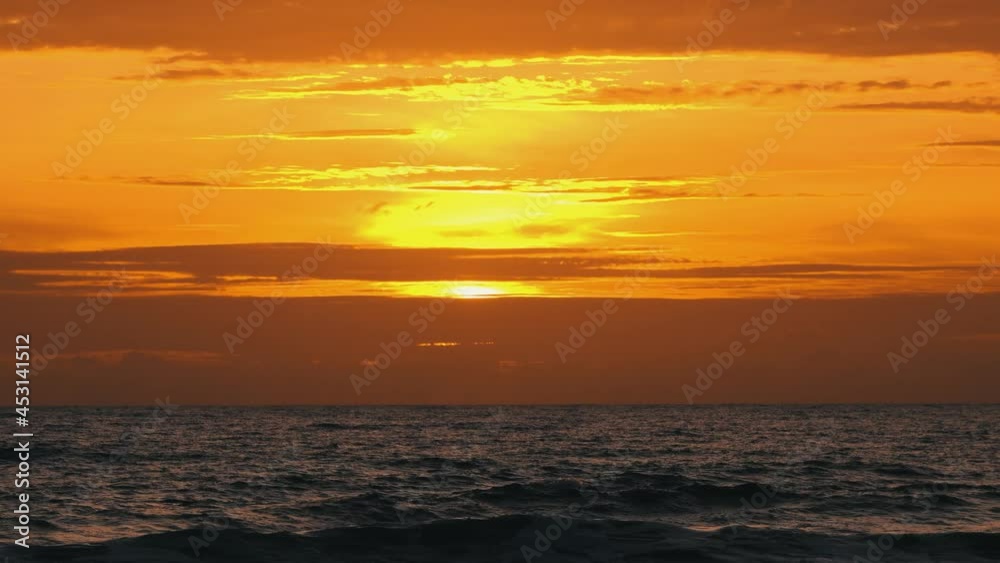 Amazing beach sunset.Beautiful sunset over ocean seamless loop.Amazing big red hot sun in reflection over ocean background Amazing beach sunset.Beautiful sunset over ocean seamless loop.Amazing big red hot sun in reflection over ocean background