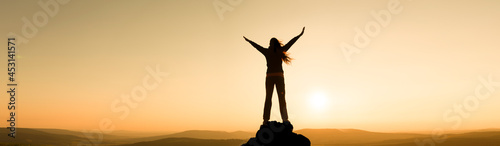 Frau in einer Landschaft mit ausgebreiteten Armen