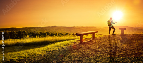 Frau mit Rucksack  in der Rhön bei Sonnenuntergang