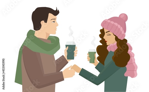 The guy holds the girl's hand. It is a date and they walk, drink coffee together. The girl is wearing a cute hat and a fluffy scarf. There is New Year's mood in the frosty air. The couple is in love.