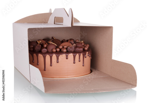 Delicious chocolate cake in takeaway cardboard box isolated on white