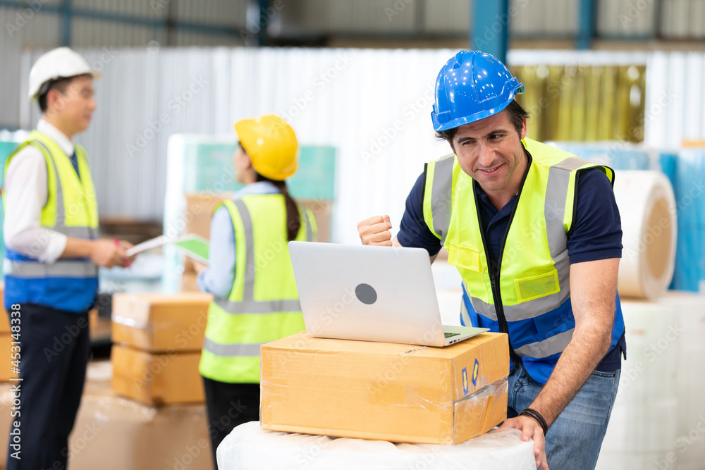 engineer or factory worker using laptop computer, raised hand for celebrating joyful news engineer or factory worker using laptop computer, raised hand for celebrating joyful news