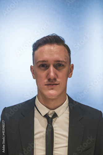Close-up formal portrait of young handsome caucasian business man in elegant business suit with the tie. Photo of the documents © Aleksandr