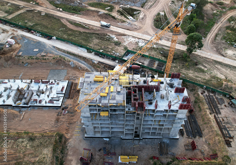 Tower crane on construction site during formwork. Arial view of the cranes the conctruct the high-rise building. Construction and the built environment. Pouring concrete into the formworks