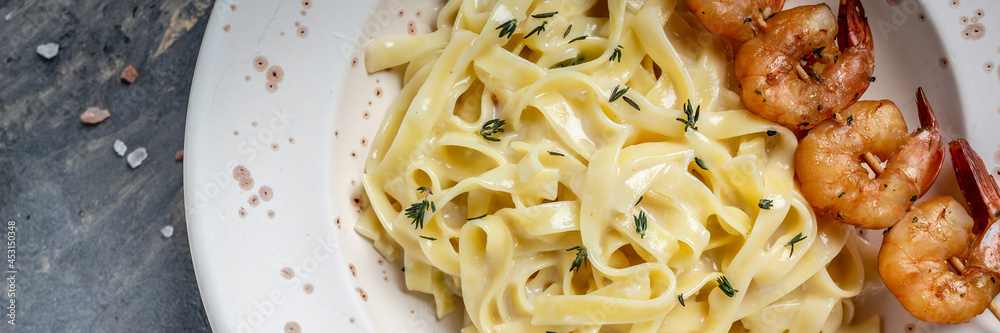 fettuccine pasta with Prawns or Shrimps, lemon and garlic, Italian pasta fettuccine. Italian food, top view. Food recipe background. Close up fettuccine pasta with Prawns or Shrimps, lemon and garlic, Italian pasta fettuccine. Italian food, top view. Food recipe background. Close up
