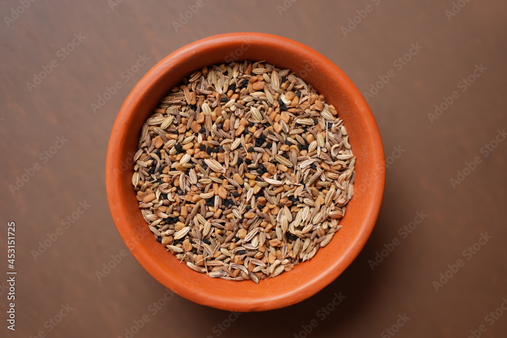 Some dry roasted Cumin seeds on a clay bowl on top of brown background Some dry roasted Cumin seeds on a clay bowl on top of brown background