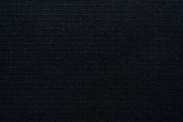 Textile. The material is gray or black in a small check. Fabric background with small squares. Texture