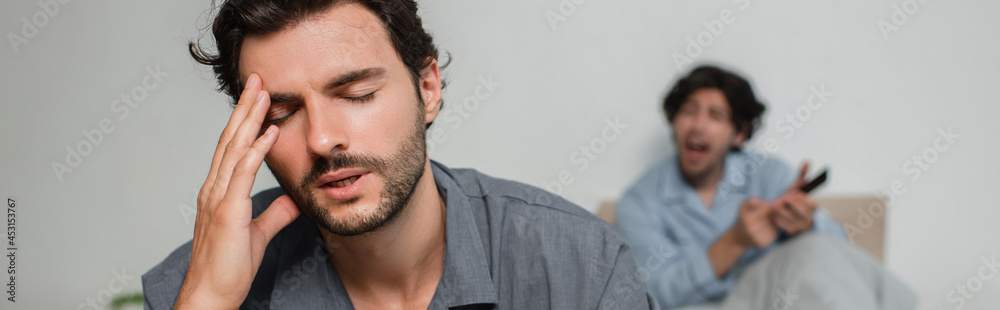 man suffering from headache while quarrelling with boyfriend, banner man suffering from headache while quarrelling with boyfriend, banner