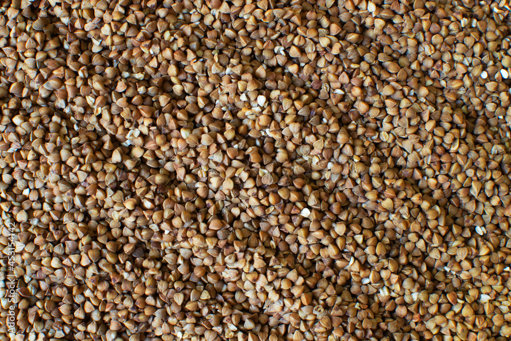 Dry buckwheat, raw grains. Texture. Healthy nutrition concept. Horizontal orientation. Buckwheat contains a large amount of vitamins and minerals. Top view. Dry buckwheat, raw grains. Texture. Healthy nutrition concept. Horizontal orientation. Buckwheat contains a large amount of vitamins and minerals. Top view.