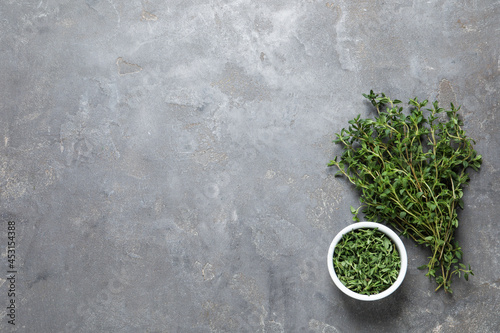 Aromatic thyme on grey table, flat lay. Space for text