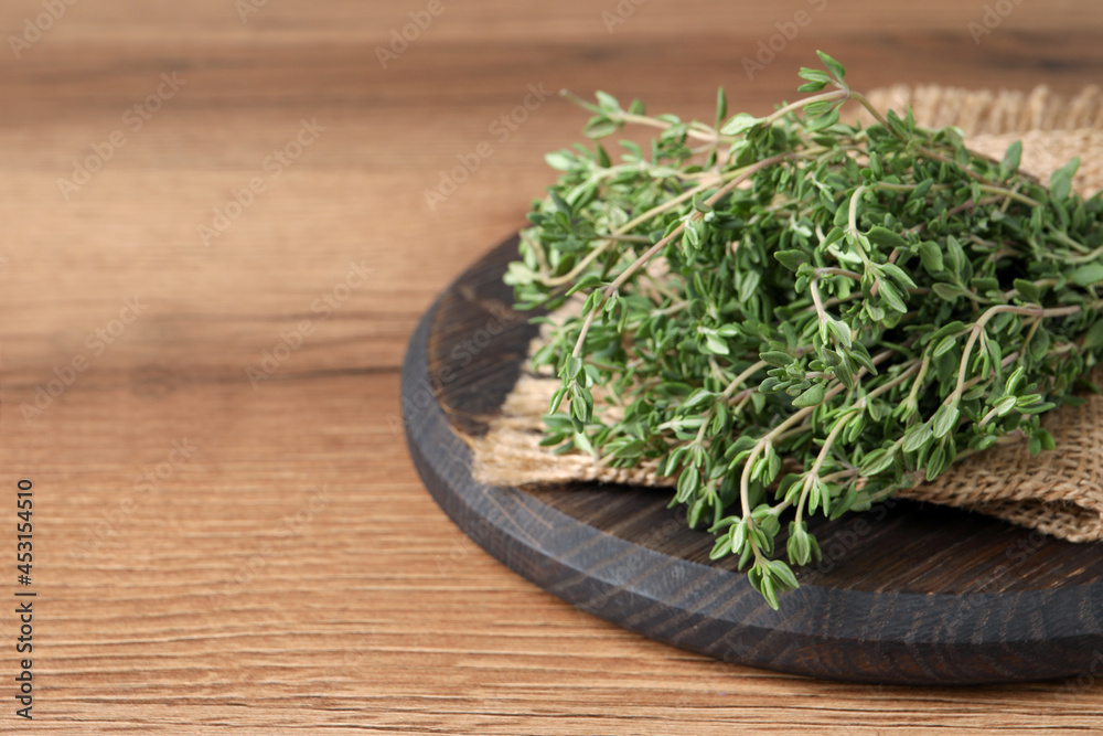Bunch of aromatic thyme on wooden table, closeup. Space for text Bunch of aromatic thyme on wooden table, closeup. Space for text