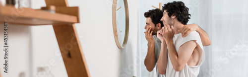 happy gay couple applying eye patches in bathroom, banner © LIGHTFIELD STUDIOS