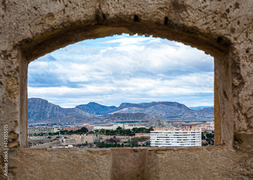 Sale inside the castle of Santa Barbara and in the background we see the city of Alicante on a cloudy day. 