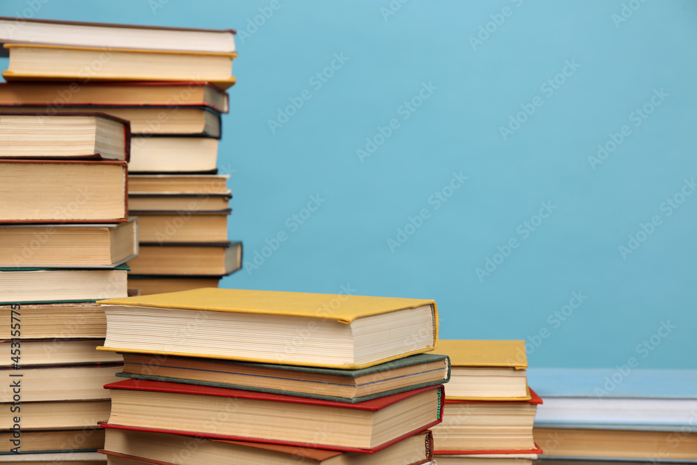 Many hardcover books on turquoise background, space for text. Library material Many hardcover books on turquoise background, space for text. Library material