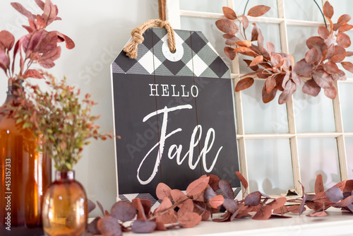 Fotografie Closeup of Hello Fall sign and leaves on a mantel decorated for autumn