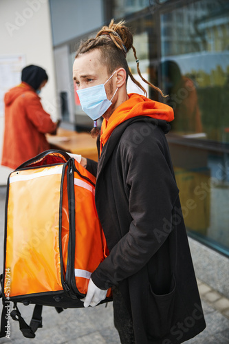 Young man working as courier during quarantine