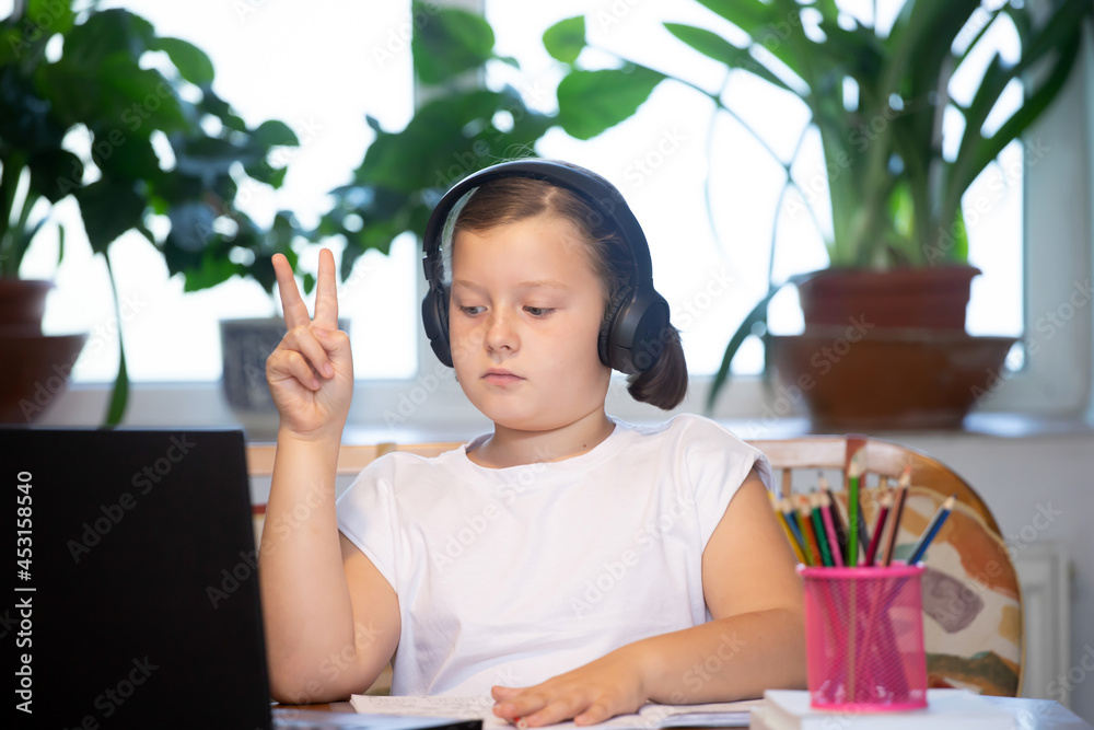 Study online with video call teacher. Young girl learn online and looking at laptop at home.Social distancing. Study online with video call teacher. Young girl learn online and looking at laptop at home.Social distancing.