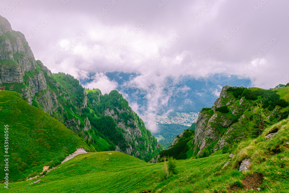 Landscape photography of a ravine in the mountains in summer time with clouds and misty weather. Photography was taken next to Caraiman cabin, Romania Landscape photography of a ravine in the mountains in summer time with clouds and misty weather. Photography was taken next to Caraiman cabin, Romania