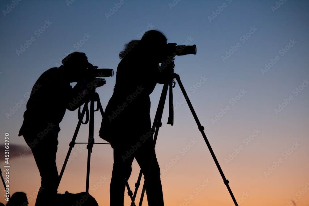 Siluetas  en el atardecer de artistas fotógrafos con sus cámaras y tripodes desde la montaña / Silhouettes in the sunset of photographic artists with their cameras and tripods from the mountain 