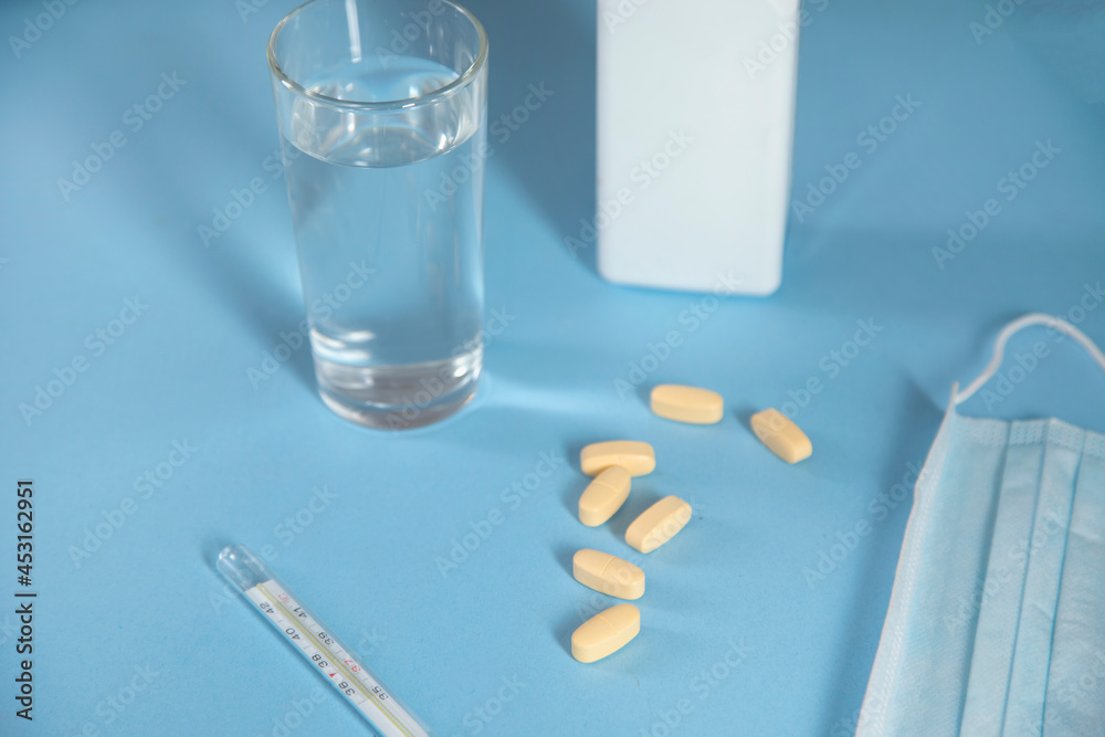 glass of water with drug and thermometer