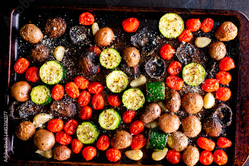 Italian Oven Roasted Vegetables on a Sheet Pan: Roasted grape tomatoes, zucchini, mushrooms, red potatoes, garlic cloves photo