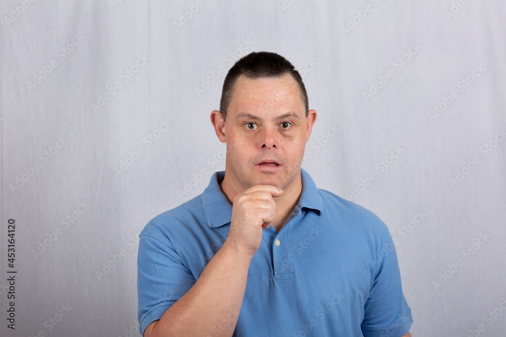 a happy man with Down syndrome in a white background photo studio wearing jeans a happy man with Down syndrome in a white background photo studio wearing jeans