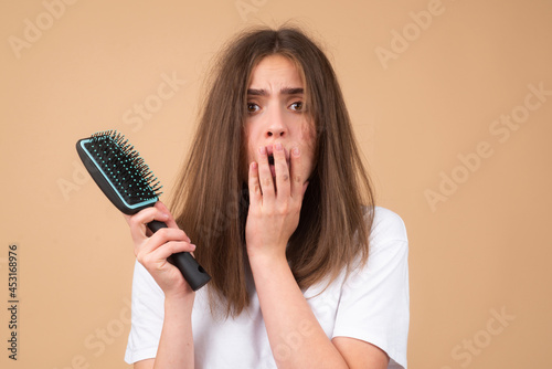 Haircare. Straightening woman and treatment of the hair. Girl with straight brushed hair. Hair tangling problem. Damaged hair combing.