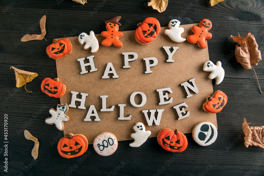 Orange gingerbread cookies and incription Happy halloween on black wooden table. Postcard Happy Halloween sweet background Orange gingerbread cookies and incription Happy halloween on black wooden table. Postcard Happy Halloween sweet background