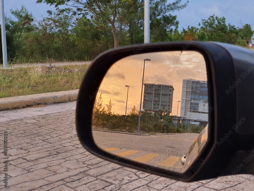 Atardecer reflejado en el espejo de un automovil.
