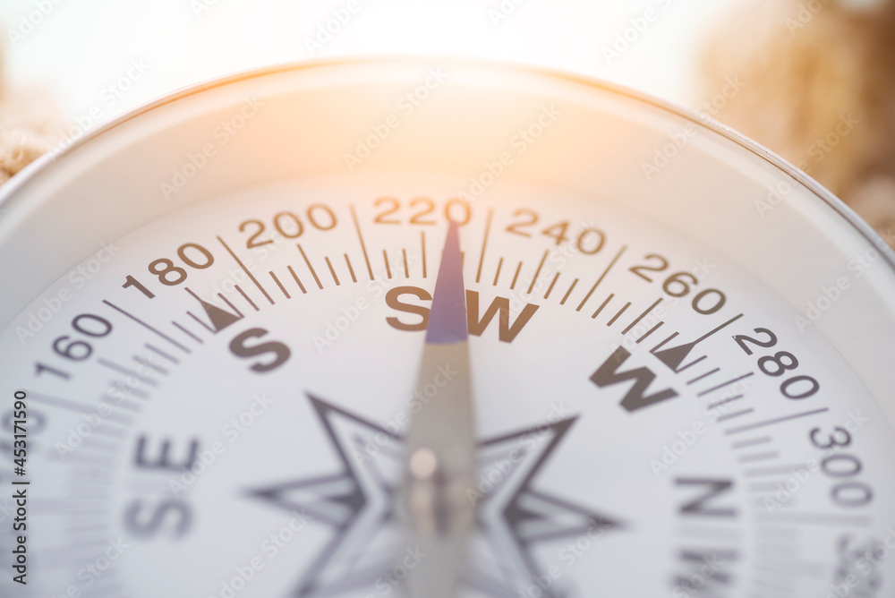 Compass arrow close up. Compass with glare of sunlight Compass arrow close up. Compass with glare of sunlight