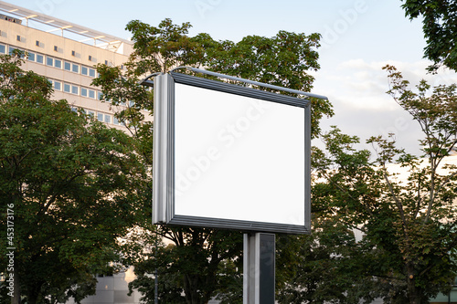 Mockup of a billboard poster next to a street. Template for an election campaign poster outdoor. Blank advertisement board with no people in the city. Place for a commercial ad.