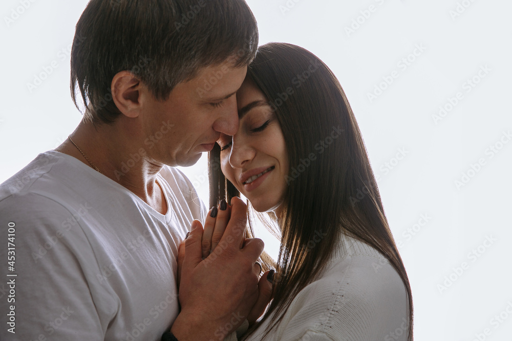couple in love hugs on a light solid background couple in love hugs on a light solid background
