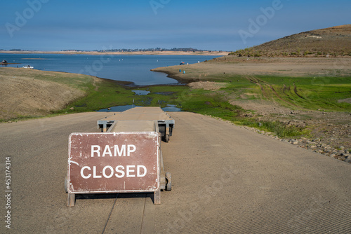 Photo of a boat ramp closed sign at a drought-stricken California State Recreation area. Water levels are critically throughout the stateʻs reservoirs. photo