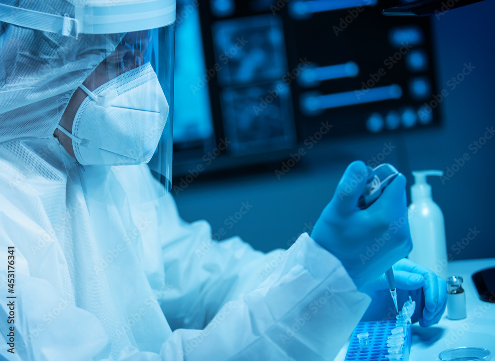 Scientist works in a modern scientific lab using laboratory equipment, microscope and computer technology. Invention of new vaccines. Concept of Science and Health.