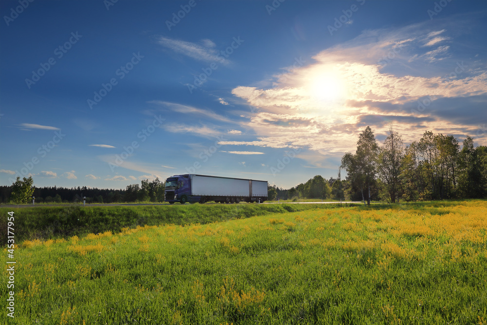 Obraz premium Landscape with a moving truck at sunset 