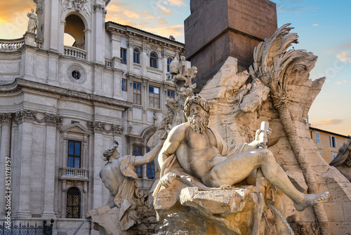 Close up of Bernini's Fountain of the Four Rivers and obelisk in front of Sant'Agnese in Agone church in Rome Italy at sunset.