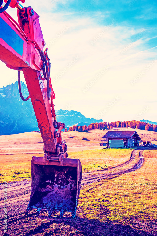 Abstract landscape with excavator bucket and road in Alpe di Siusi in the Dolomites. The Italian Alps.