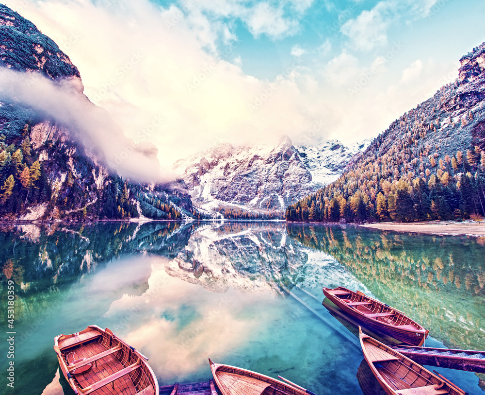 Magical beautiful fairy autumn landscape with boats on the lake on Fanes-Sennes-Braies natural park in the Dolomites in South Tyrol, Alps, Italy, Europe. Exotic amazing places. (harmony - concept)