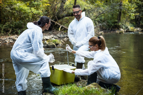 Tableau sur toile Young scientists take water samples from the mountain river