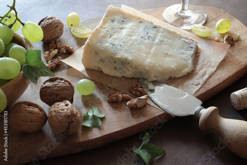 Delizioso formaggio blu con noci, uva, coltello e bicchiere di vino rosso su tagliere di legno. Cibo italiano. Gorgonzola. Direttamente sopra.