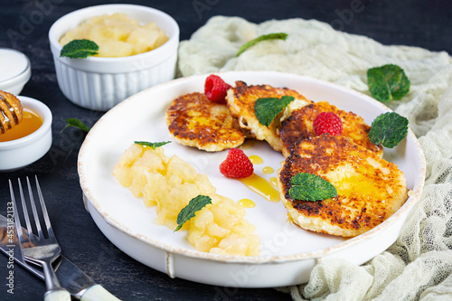 Curd cheese pancake with sour cream, honey and berries. Delicious syrniki with caramelized pears