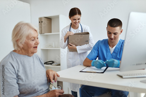 an elderly woman sitting at a doctor's appointment with a nurse treatment
